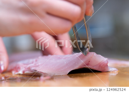 魚の骨を抜く女性の手元 124962524