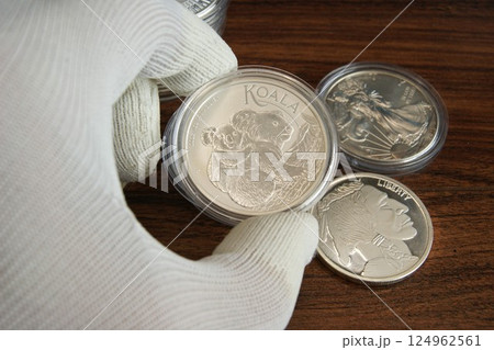 An Australian silver coin in the hand of a numismatist. Pure silver coin Koala An Australian silver coin in the hand of a numismatist. Pure silver coin Koala 124962561