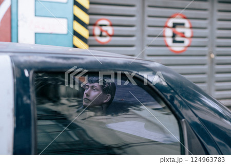 A plastic head of man gazes out of a police van window, reflecting on his situation 124963783