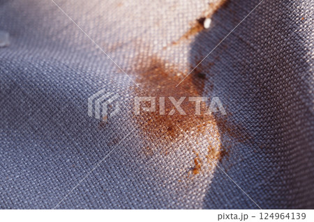 Stained Fabric CloseUp Detailed View of Patterned Material Featuring an Orange Mark Stained Fabric CloseUp Detailed View of Patterned Material Featuring an Orange Mark 124964139
