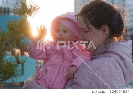 Mother and child enjoying a sunset together in spring while exploring nature outdoors 124964624