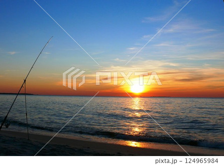 Fishing from the sandy beach, spinning rods and fishing rods stand on the shore 124965984