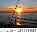 Fishing from the sandy beach, spinning rods and fishing rods stand on the shore 124965985