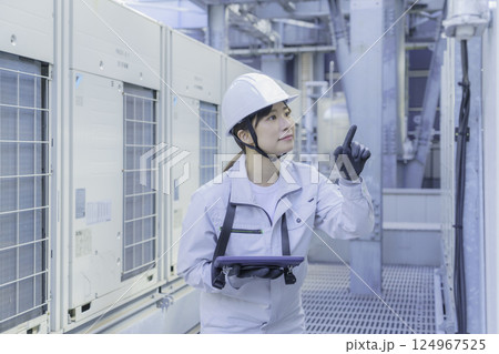 ビルの屋上で点検作業をする若い女性作業員　撮影協力：学校法人電波学園 東京電子専門学校 124967525
