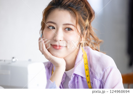 頬杖をついて笑顔の女性 124968694