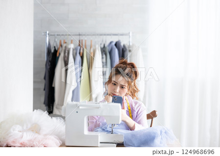 スマホを見て悩む女性 124968696