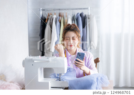 スマホを見てガッツポーズをする女性 124968701