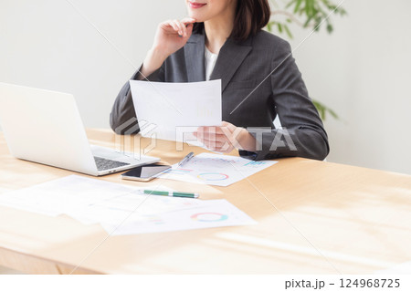 オフィスで資料を見ながら考える女性 124968725