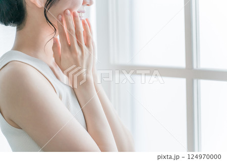 窓際でお肌を触る女性(美容・スキンケア・基礎化粧品イメージ) 窓際でお肌を触る女性(美容・スキンケア・基礎化粧品イメージ) 124970000