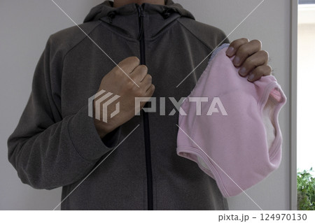 暗い部屋で子供のパンツを持つ男性。犯罪イメージ 暗い部屋で子供のパンツを持つ男性。犯罪イメージ 124970130