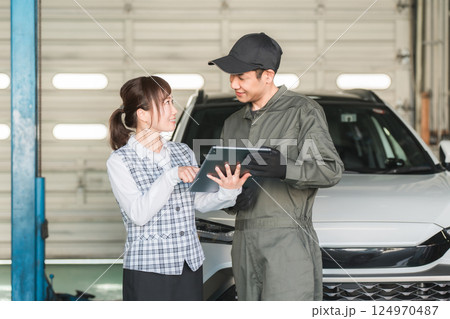 整備工場のピットでタブレットを見る従業員の男女(自動車整備工場・民間車検場・スタッフ) 整備工場のピットでタブレットを見る従業員の男女(自動車整備工場・民間車検場・スタッフ) 124970487