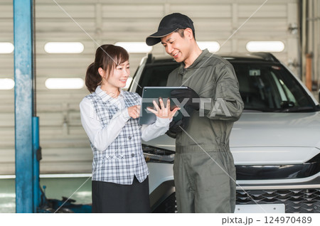 整備工場のピットでタブレットを見る従業員の男女（自動車整備工場・民間車検場・スタッフ） 124970489