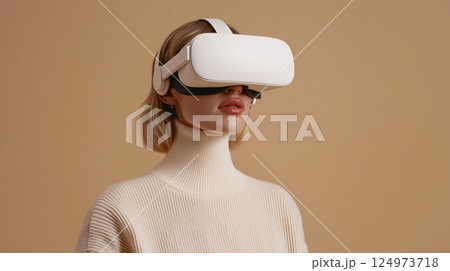 Young Woman Wearing Virtual Reality Headset with Soft Beige Background, Engaging in Immersive  124973718