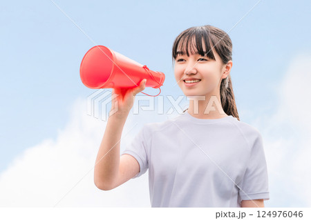 メガホンを持って応援する体操着姿の中学生,高校生,小学生の女の子 124976046