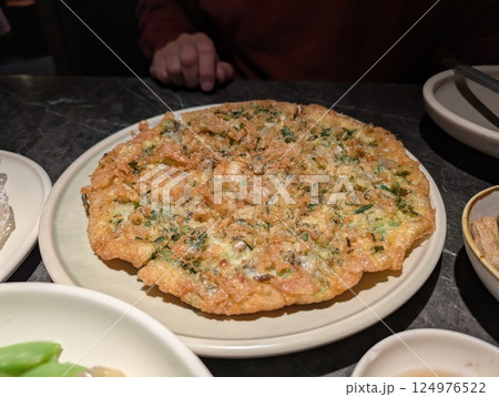 大皿にピザのような揚げお好み焼きのような料理のある風景 大皿にピザのような揚げお好み焼きのような料理のある風景 124976522