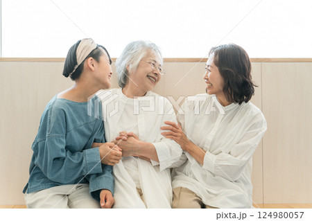 座って話をする三世代親子(孫・母親・おばあちゃん) 座って話をする三世代親子(孫・母親・おばあちゃん) 124980057