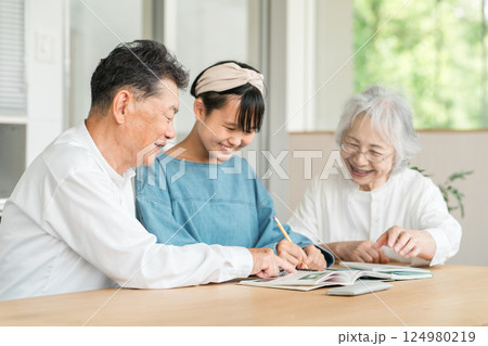 孫娘の勉強を見ている祖母と祖父（ファミリー,里帰り,宿題） 124980219