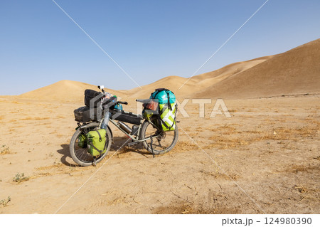Bicycle journey through the sandy landscapes of Afghanistan's desert terrain 124980390