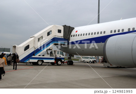 タラップ車から旅客機に搭乗する人達 124981993