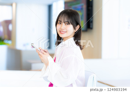 スマホを見る笑顔の女性 スマホを見る笑顔の女性 124983194
