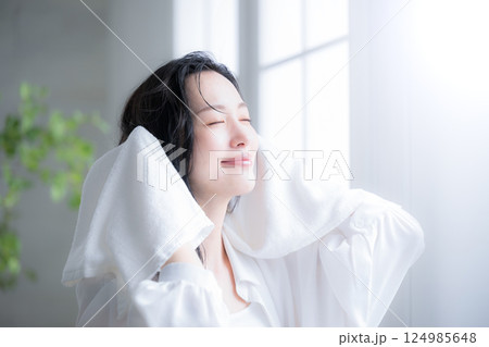 濡れた髪を乾かすタオルドライする女性　目を閉じて見上げる 124985648