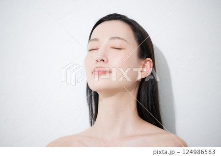 若い女性の艶と素肌感が美しい見上げるビューティーイメージの目を閉じるクローズアップ 124986583