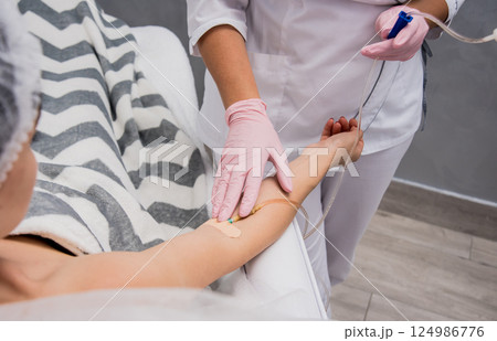 The doctor cosmetologist makes cosmetology dropper procedure. Infusion.  124986776
