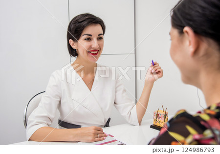 Face skin analyze system. Cosmetologist analyzing woman face.  124986793