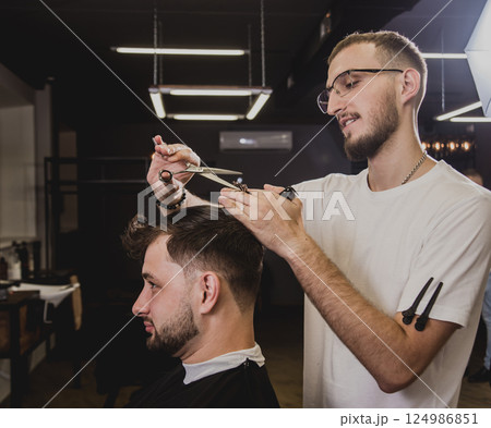 Young man with trendy haircut at barber shop. Young man with trendy haircut at barber shop. 124986851
