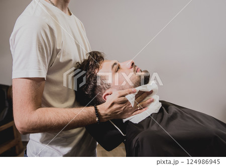 Young man with trendy haircut at barber shop.  124986945