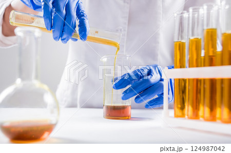 Scientist pouring organic oil. Beauty and cosmetics sciences. Scientist pouring organic oil. Beauty and cosmetics sciences. 124987042