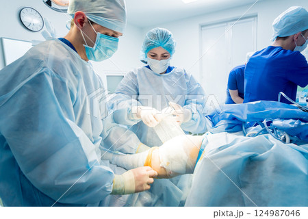 Arthroscope surgery. Orthopedic surgeons in teamwork in the operating room 124987046
