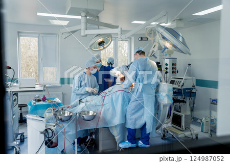 Spinal surgery. Group of surgeons in operating room with surgery equipment.  124987052