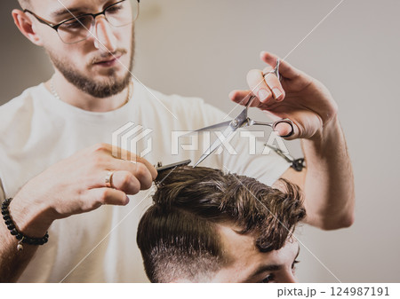 Young man with trendy haircut at barber shop. Young man with trendy haircut at barber shop. 124987191