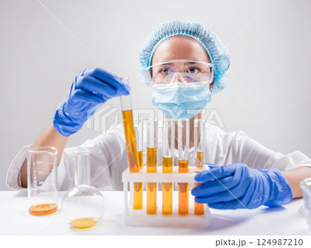 Scientist pouring organic oil. Beauty and cosmetics sciences. Scientist pouring organic oil. Beauty and cosmetics sciences. 124987210