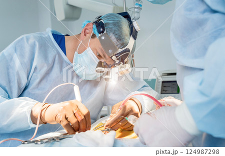 Spinal surgery. Group of surgeons in operating room with surgery equipment.  124987298