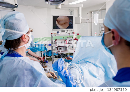 Arthroscope surgery. Orthopedic surgeons in teamwork in the operating room  124987350