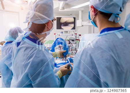 Arthroscope surgery. Orthopedic surgeons in teamwork in the operating room  124987365