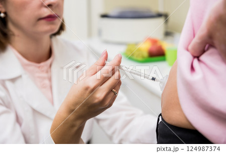 Doctor makes an injection of insulin with a catheter. Doctor makes an injection of insulin with a catheter. 124987374