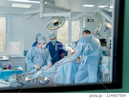 Spinal surgery. Group of surgeons in operating room with surgery equipment.  124987504