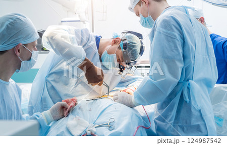 Spinal surgery. Group of surgeons in operating room with surgery equipment. Spinal surgery. Group of surgeons in operating room with surgery equipment. 124987542