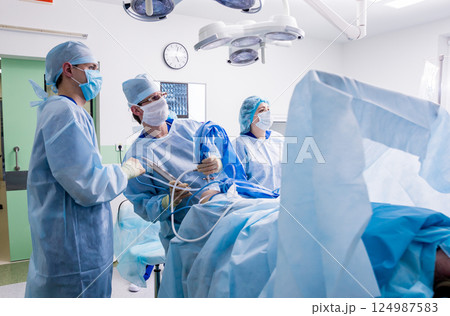 Arthroscope surgery. Orthopedic surgeons in teamwork in the operating room  124987583