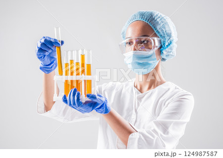 Scientist pouring organic oil. Beauty and cosmetics sciences. Scientist pouring organic oil. Beauty and cosmetics sciences. 124987587