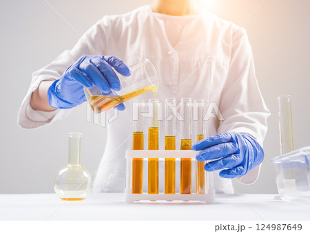 Scientist pouring organic oil. Beauty and cosmetics sciences. Scientist pouring organic oil. Beauty and cosmetics sciences. 124987649