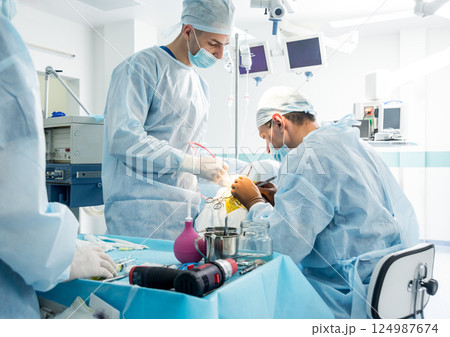 Brain surgery. Group of surgeons in operating room with surgery equipment. Brain surgery. Group of surgeons in operating room with surgery equipment. 124987674