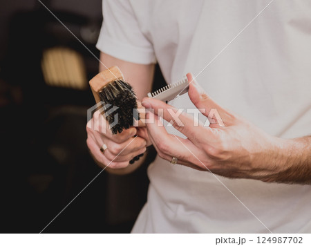 Young man with trendy haircut at barber shop. Young man with trendy haircut at barber shop. 124987702