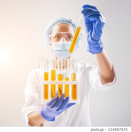 Scientist pouring organic oil. Beauty and cosmetics sciences. Scientist pouring organic oil. Beauty and cosmetics sciences. 124987835