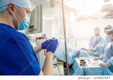 Arthroscope surgery. Orthopedic surgeons in teamwork in the operating room 124987847