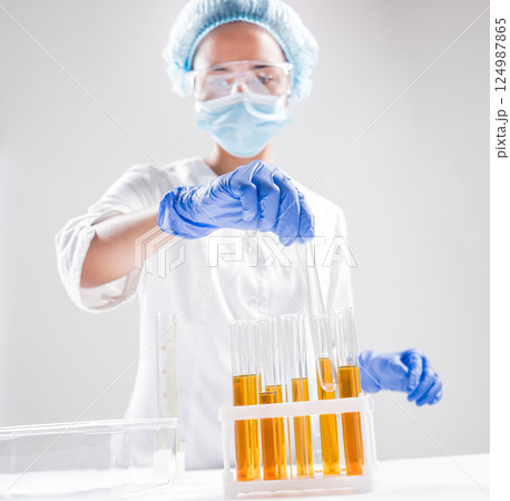Scientist pouring organic oil. Beauty and cosmetics sciences. Scientist pouring organic oil. Beauty and cosmetics sciences. 124987865