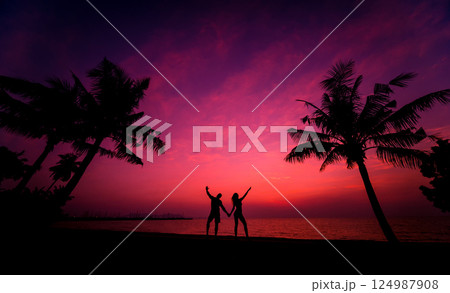 Silhouette of couple on tropical beach during sunset on background 124987908